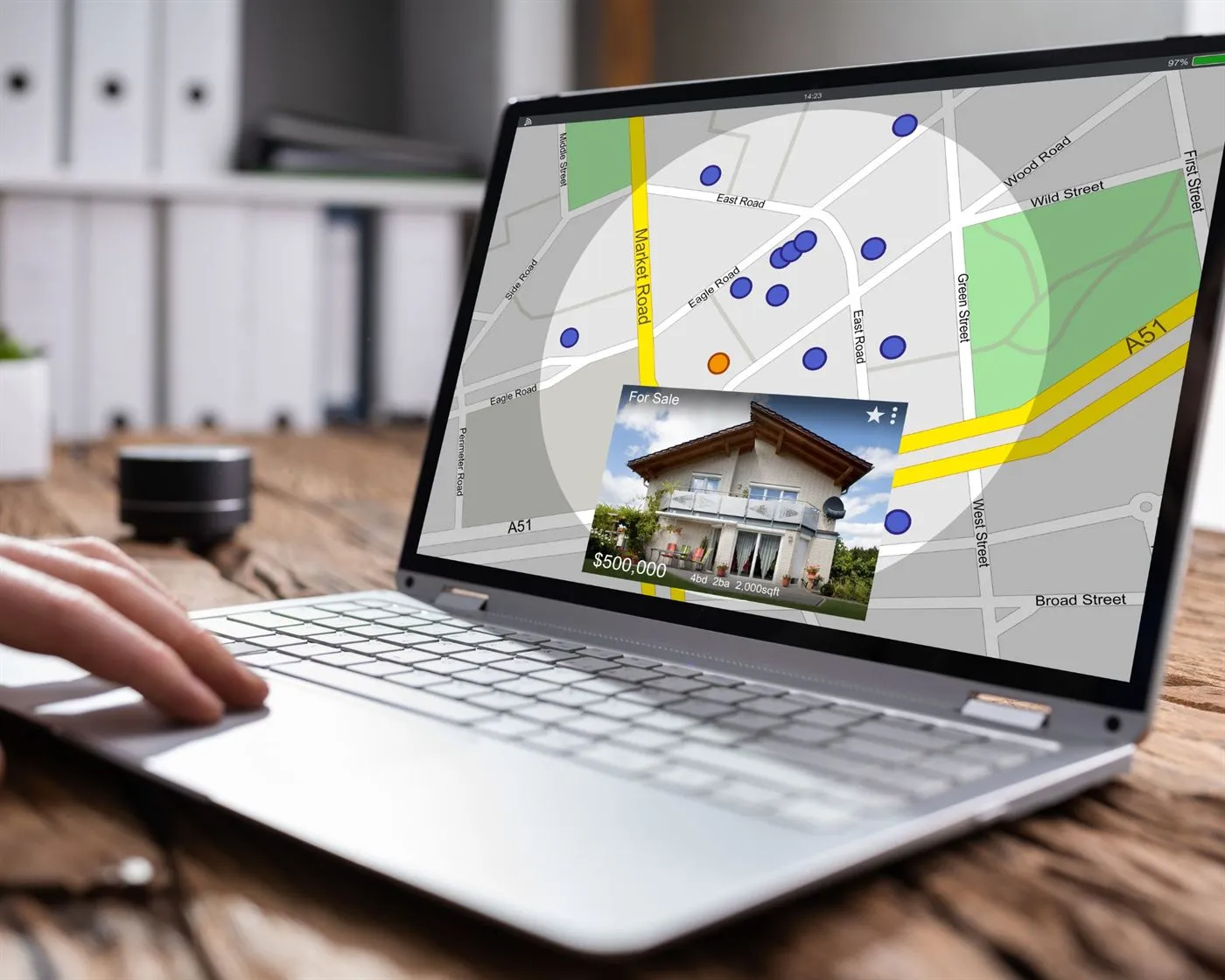 A laptop showing a property search map with a listing card