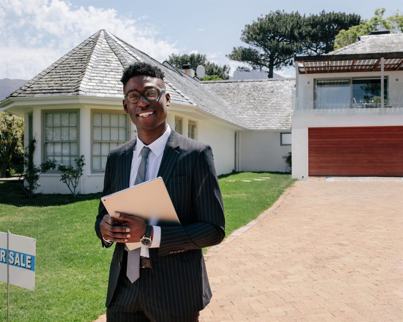 A real estate agent with a tablet outside a listed home