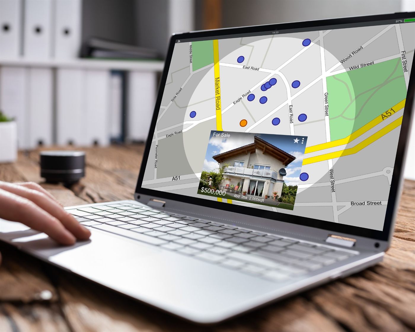 A laptop showing a property search map with a listing card