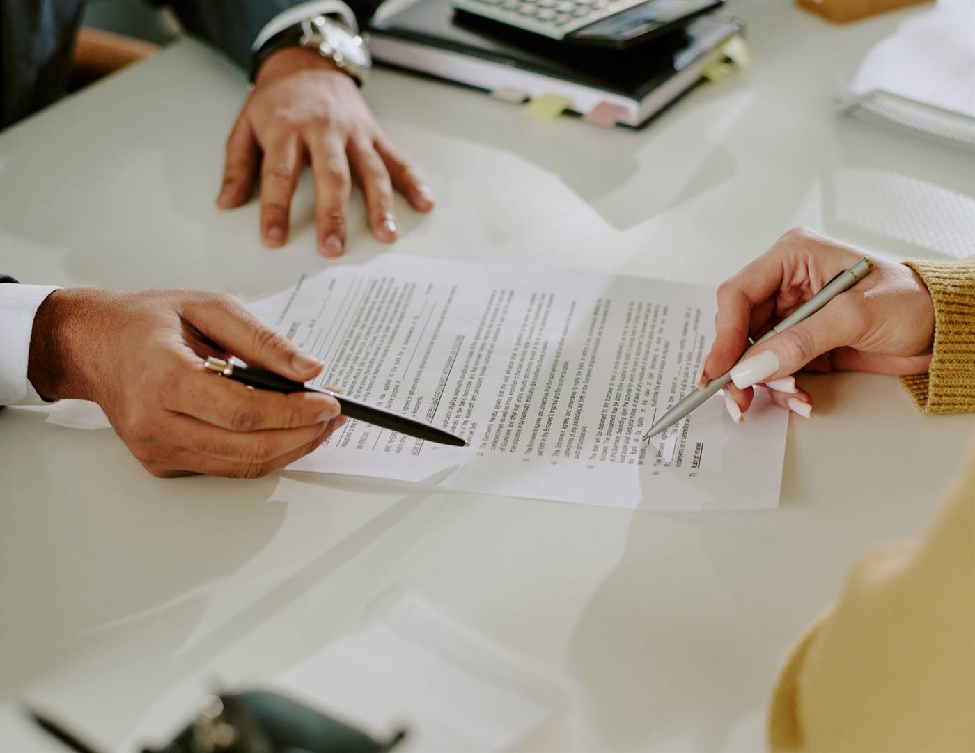 Two people reviewing and signing legal documents